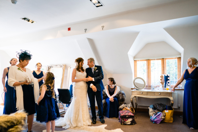 Bride with her father and family members at Nuthurst Grange Hotel in the bridal suite