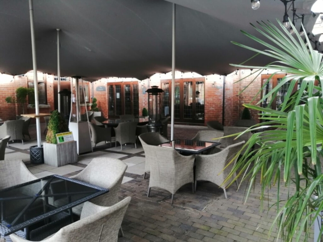 Tables set for functions outside the Stables barn at Nuthurst Grange Hotel