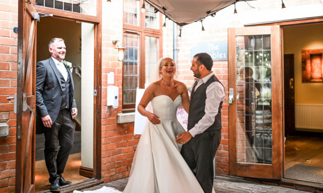 Wedding couple laughing with Mo at Nuthurst Grange