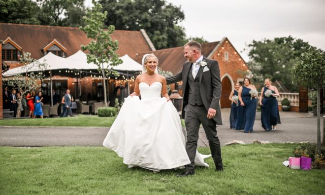 Happy wedding couple outside the Stables barn at Nuthurst Grange Hotel