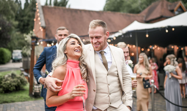 Elegant couple laughing outside the Stables at Nuthurst Grange